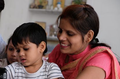 A shallow focus of a cheerful Indian family using the tablet in the house